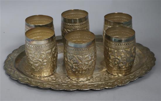 A set of six Indian white metal beakers and a tray, 44.6ozs, tray 35.5cm